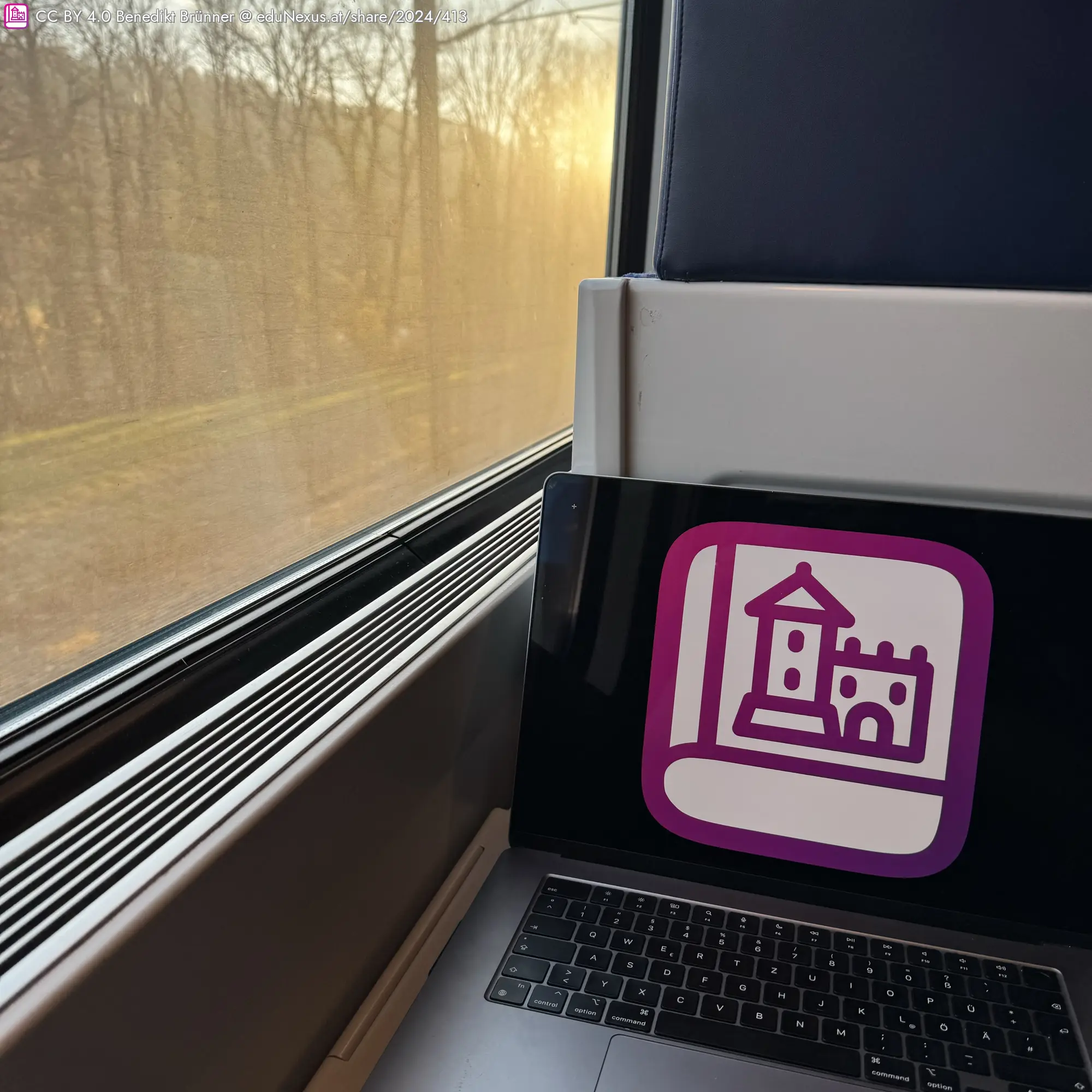 Laptop mit eduNexus Logo am Bildschirm, Zug-Fenster mit Sonnenlicht und Bäumen im Hintergrund.