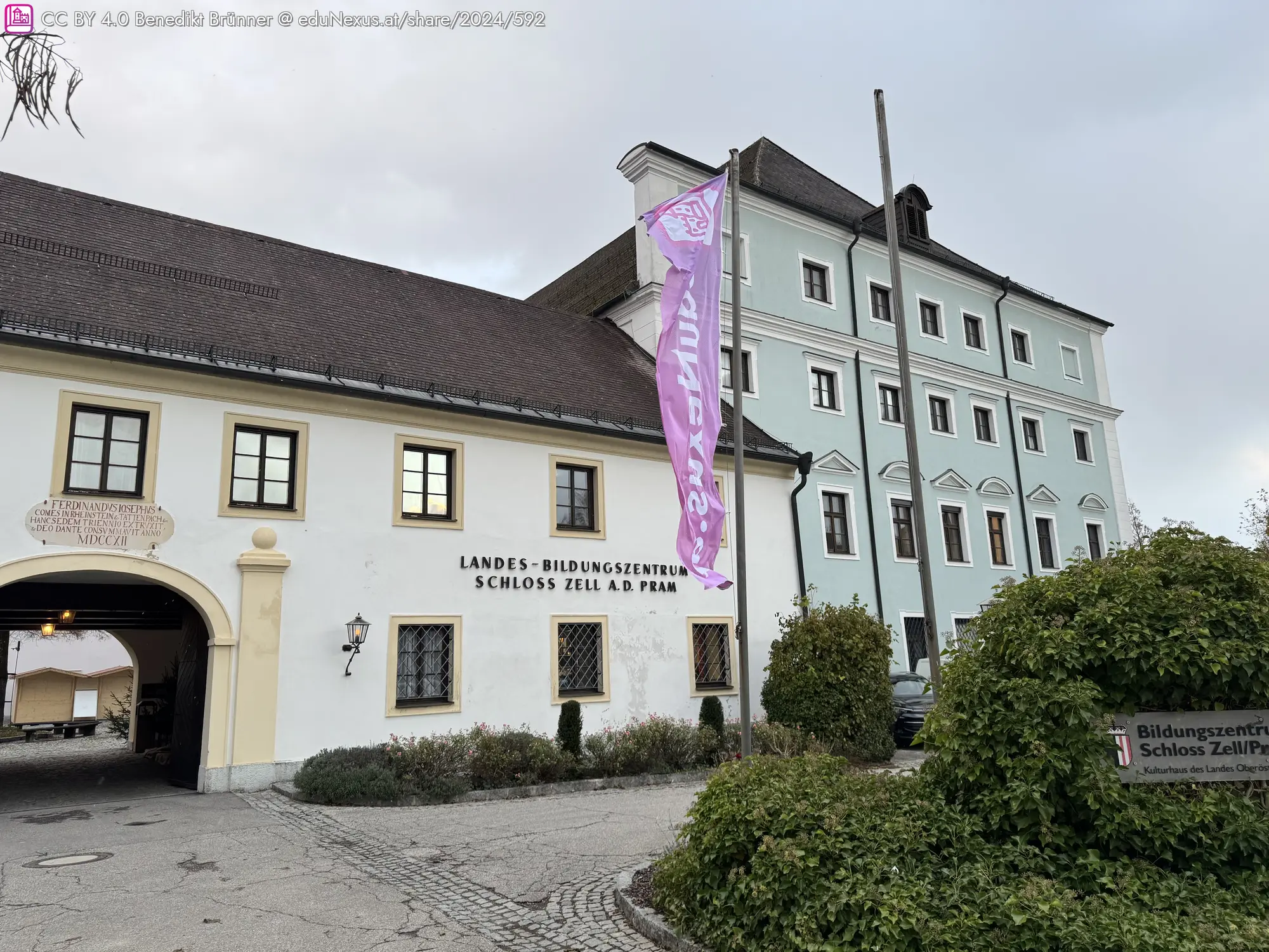 Bildungsschloss Zell an der Pram in einem historischen Gebäude. Eine Fahne mit Schriftzug weht vor der Fassade.